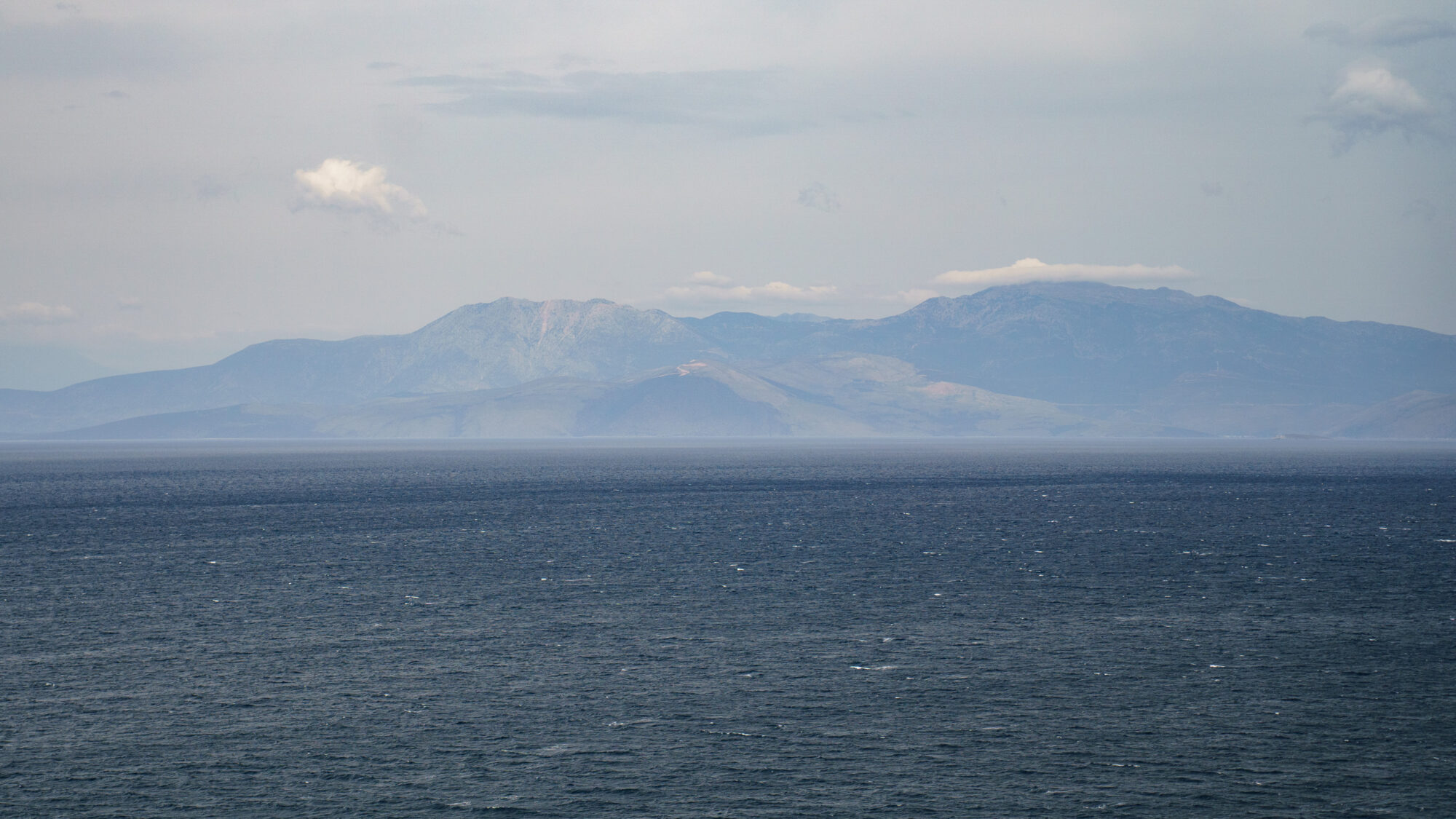 View of mountain range behind ocean